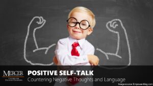 A young boy stands in front of a chalkboard. He is wearing oversized round glasses, a white collared shirt, and a red tie. His arms are crossed confidently in front of his chest, and there is an image of muscled arms flexing draw on the chalkboard behind him. The image is a thumbnail for the training entitled Positive Self-Talk: Countering Negative Thoughts and Language